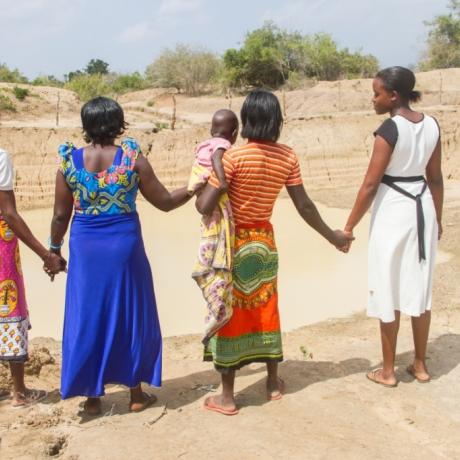 Four women stand together looking into the distance